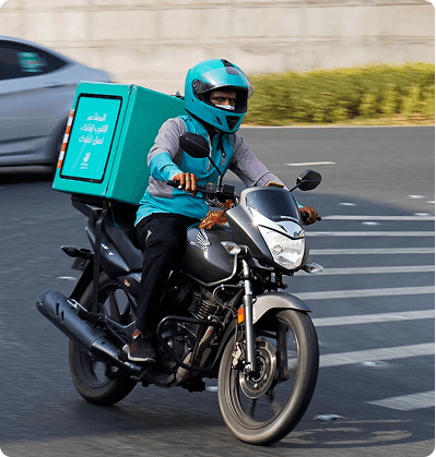 Delivery rider in a blue helmet riding a motorcycle